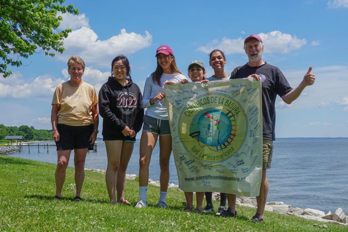 Group of people standing with banner and smiling