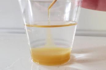 A closeup of dna extraction of applesauce in a small cup.