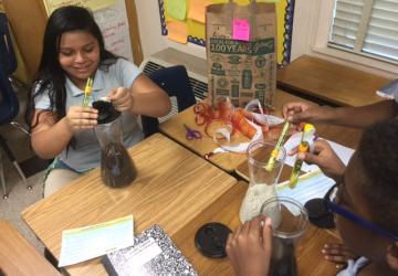 student smiling with soil