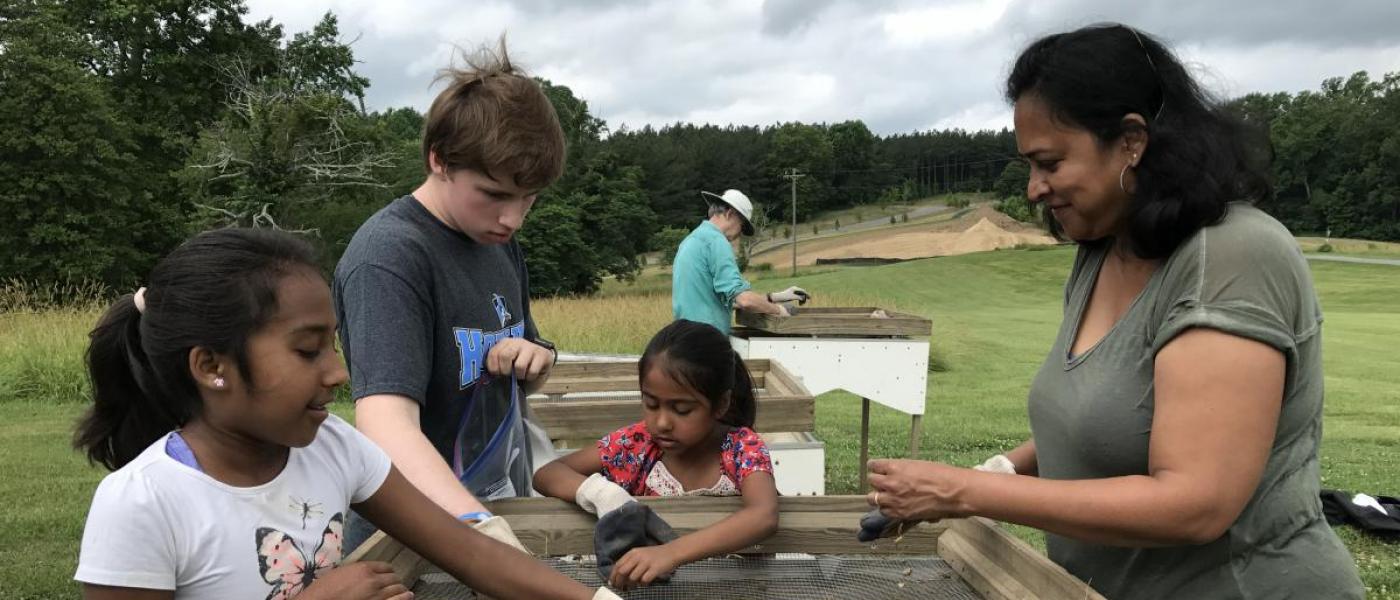 Family sieves soil on field