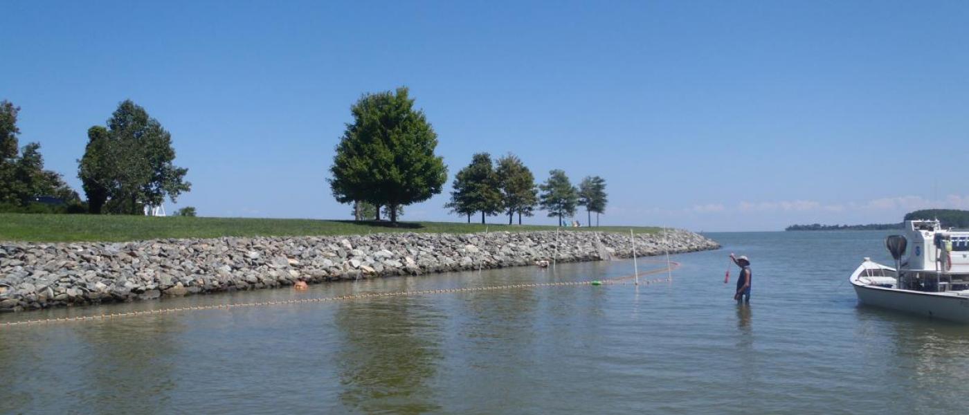 Boat beside rocky shoreline with riprap