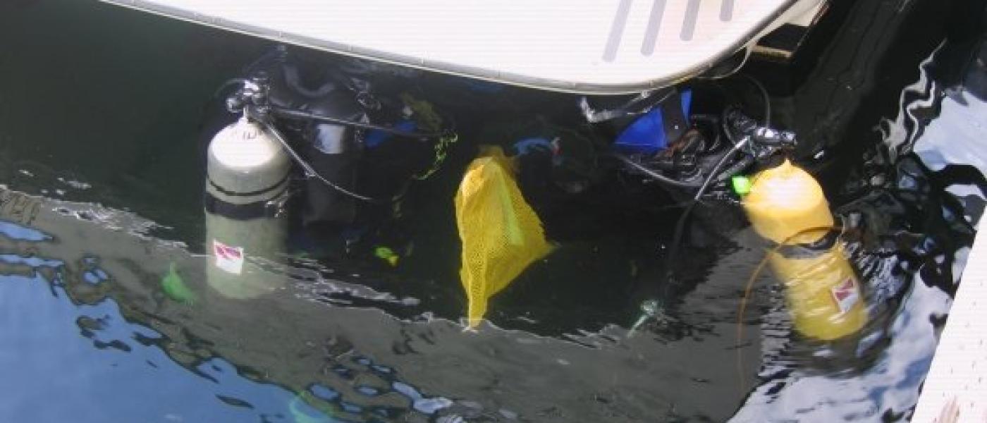 divers survey the hull of a recreational vessel