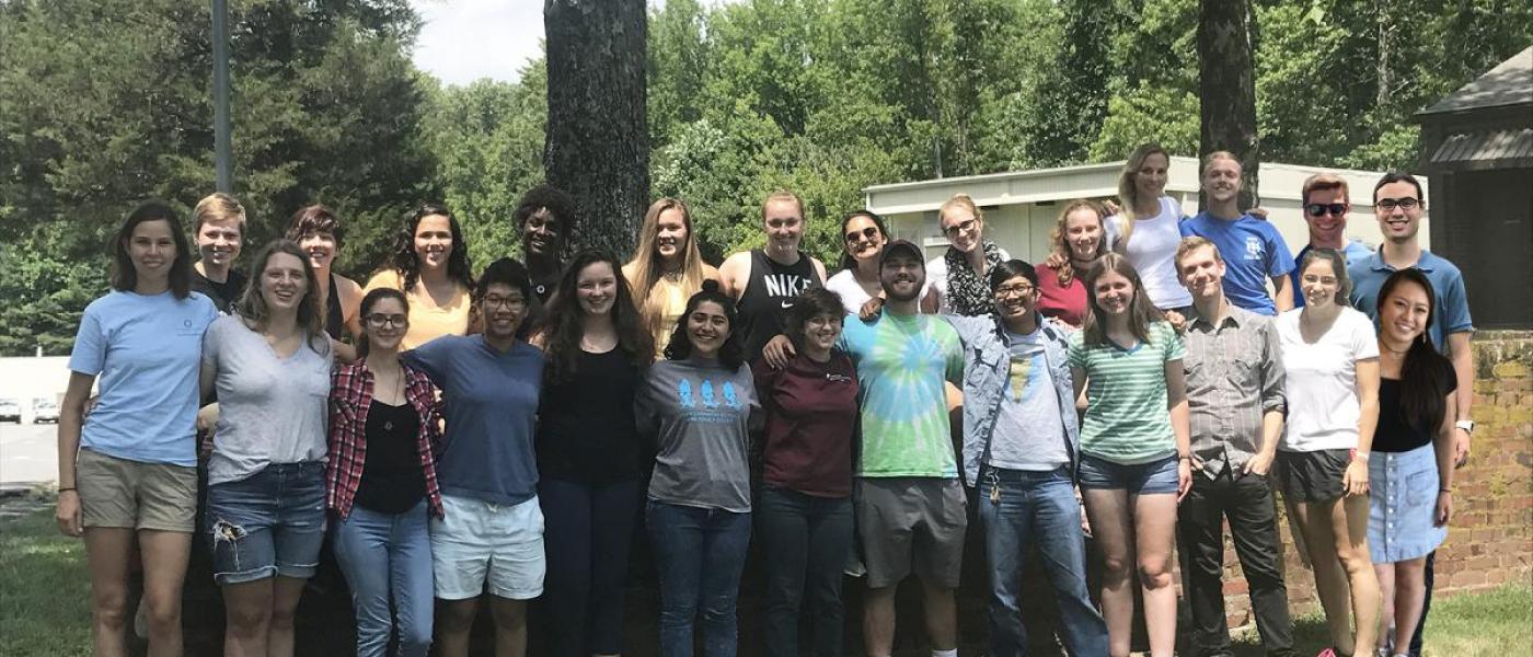 Summer interns pose for a group picture on the grass