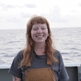 Profile picture of Tessa Beaver wearing brown overalls with a gray T-shirt. 