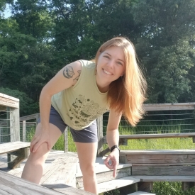 Calli Wise points at river otter scat on a boardwalk at the Smithsonian Environmental Research Center.